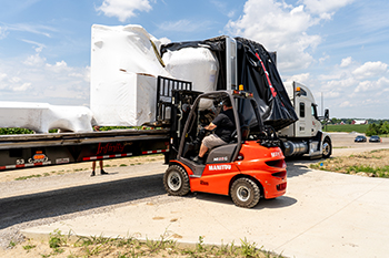 Conestoga trailer opened for side loading of industrial freight for Buchanan Hauling and Rigging.