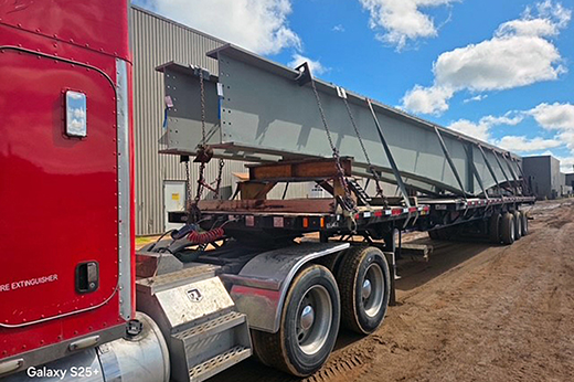 Buchanan Hauling flatbed transporting structural steel for a commercial construction or industrial project.