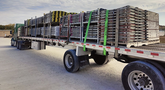 Structural steel beams loaded on a Buchanan Hauling flatbed trailer for commercial freight transportation.