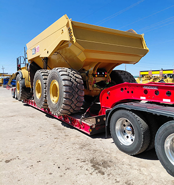 Buchanan Hauling RGN trailer transporting heavy construction equipment for a commercial customer.