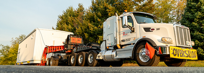 Industrial power equipment loaded for specialized heavy haul transportation by Buchanan Hauling and Rigging.