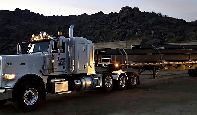 Flatbed trailer prepared for a scheduled industrial freight shipment requiring open deck transportation.