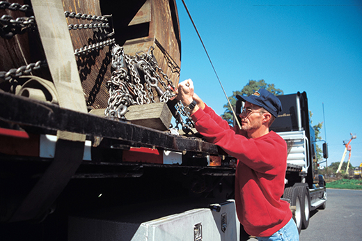 manufacturing equipment being loaded onto flatbed trailer for freight hauling