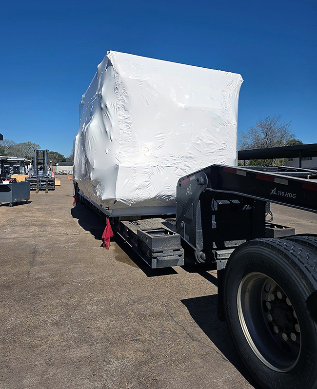 Industrial freight transport truck carrying oversized equipment.