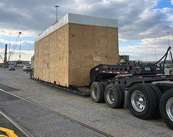 Heavy manufacturing press prepared for transport by a lowboy RGN trailer Heavy manufacturing press prepared for transport by a lowboy RGN trailer