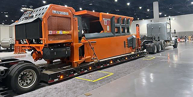 Lowboy trailer hauling heavy industrial machinery.