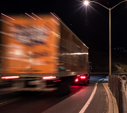 Expedited freight truck transporting emergency shipment at night.