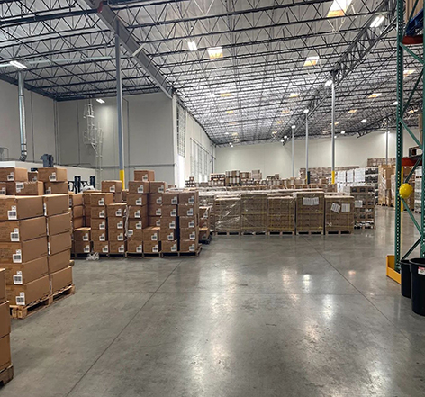 Freight truck delivering shipments to logistics warehouse facility.
