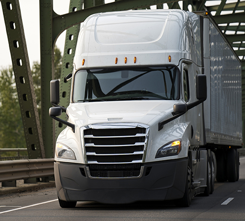Nationwide freight carrier trucks transporting cargo across interstate highway.
