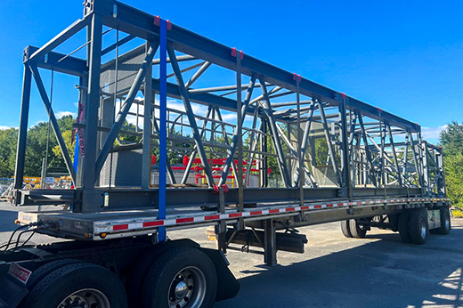 commercial freight transport loading industrial materials onto flatbed trailer