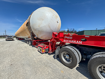Heavy haul trailer carrying a large cylindrical vessel during industrial transportation Heavy haul trailer carrying a large cylindrical vessel during industrial transportation