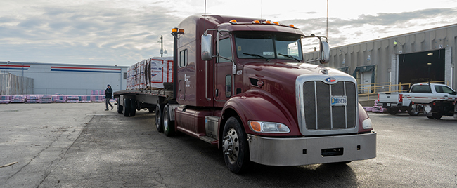 flatbed truck delivering construction materials to job site