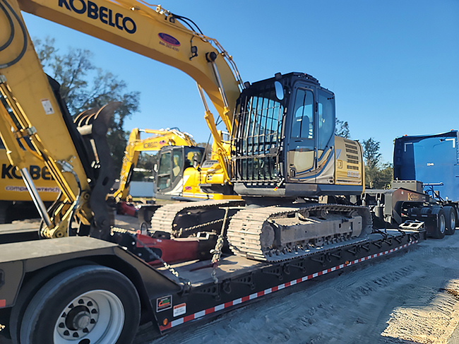 excavator loaded onto heavy haul trailer for equipment transport