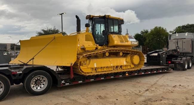 bulldozer being transported on specialized equipment hauling trailer