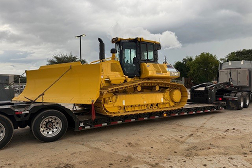 bulldozer being transported on specialized equipment hauling trailer