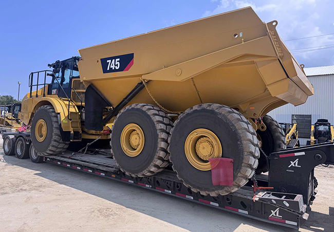 heavy construction equipment secured on flatbed trailer