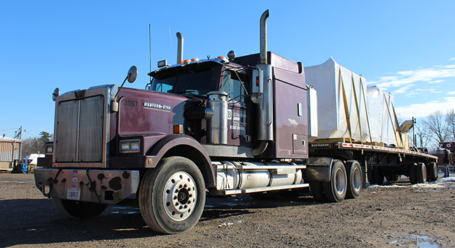 Flatbed freight transporting construction materials to job site