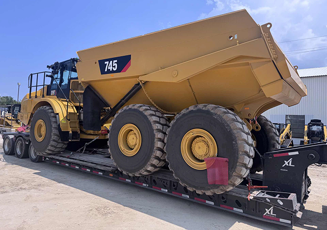 Heavy haul trucking transporting large construction equipment on lowboy trailer