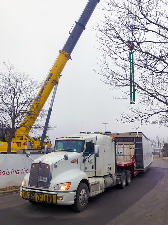 Buchanan Hauling and Rigging transports an HVAC unit on one of their stepdeck trailers to a hospital construction crew jobsite.