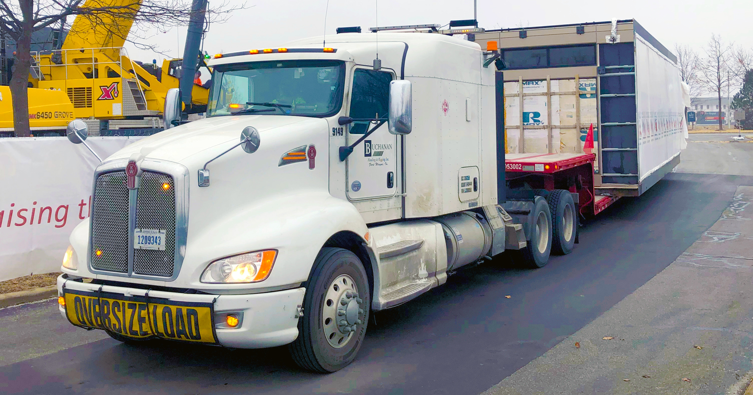 Buchanan Hauling and Rigging transports an HVAC unit on one of their stepdeck trailers to a hospital construction crew jobsite.