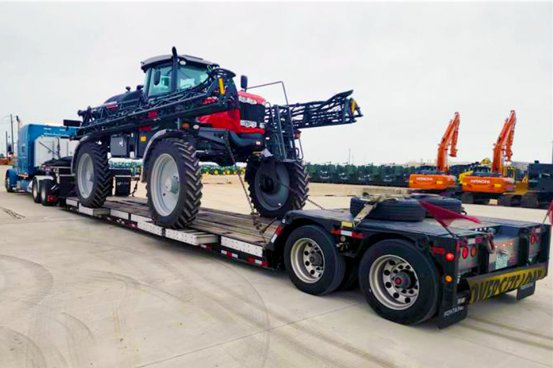 Buchanan Hauling & Rigging transporting an agricultural sprayer.