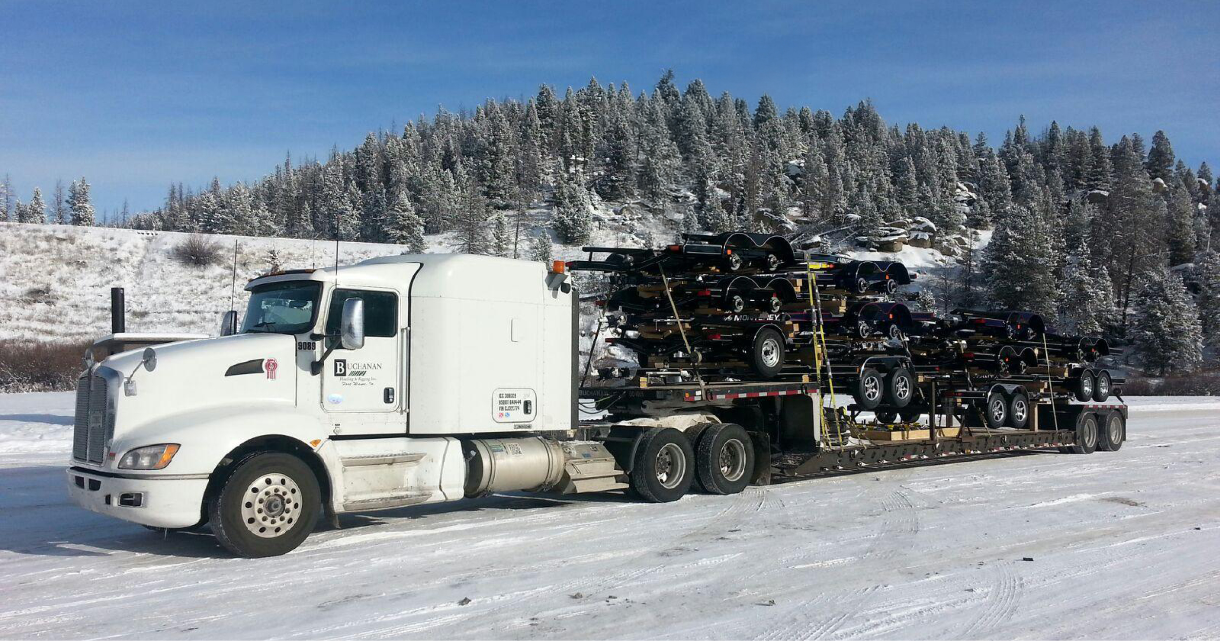 Buchanan Hauling step deck flatbed transporting automotive parts.