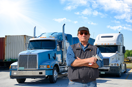 Former military CDL driver standing beside a Buchanan Hauling & Rigging tractor during the Freedom Haulers initiative.