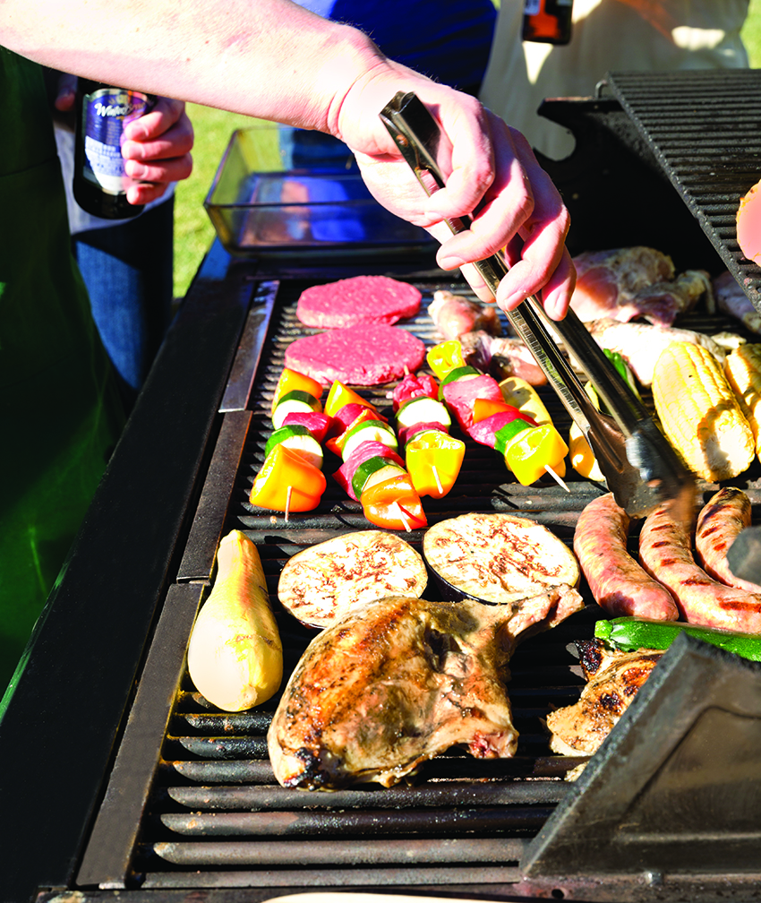 Buchanan Hauling cooking meats and vegetables on a grill for the Buchanan Family.