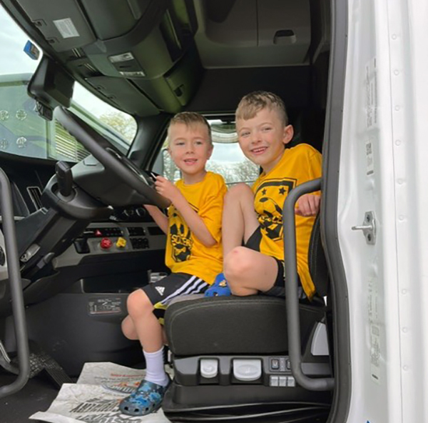 A couple of boys find out what it is like to be a trucker as they sit in one of Buchanan Hauling's rigs.